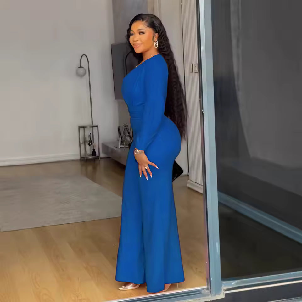 Woman in a blue dress standing in front of a mirror.