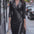 Person wearing a black leather dress on a city street.