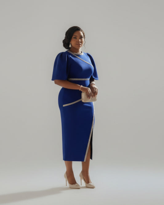 Woman in a blue dress with silver accents standing in a formal setting.