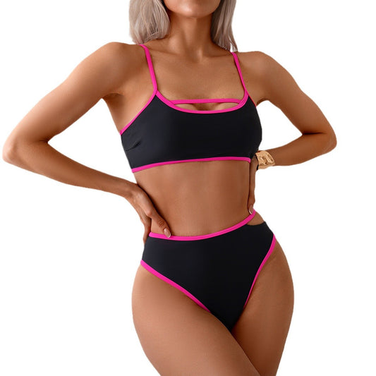 Black bikini with pink accents worn by a model on a white background