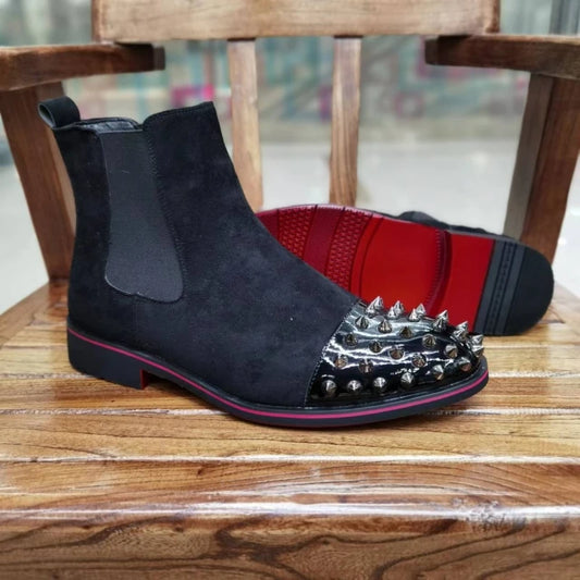 Black suede boot with silver spikes on a wooden chair