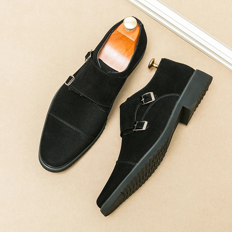 Black suede shoes with buckles on a beige surface