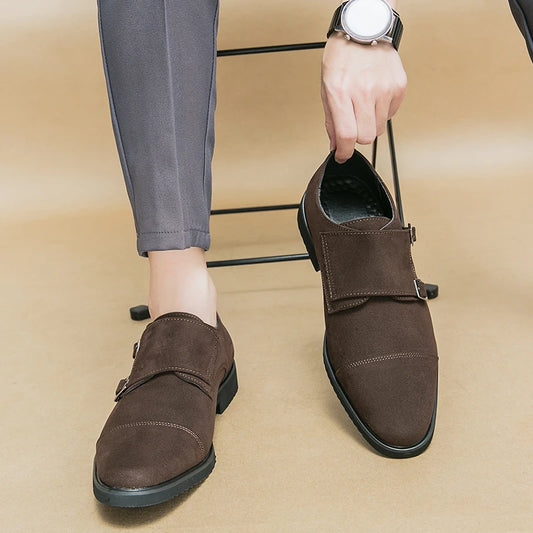 Brown shoes with a strap held by a hand on a beige background