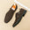 Brown suede shoes with buckles on a beige surface