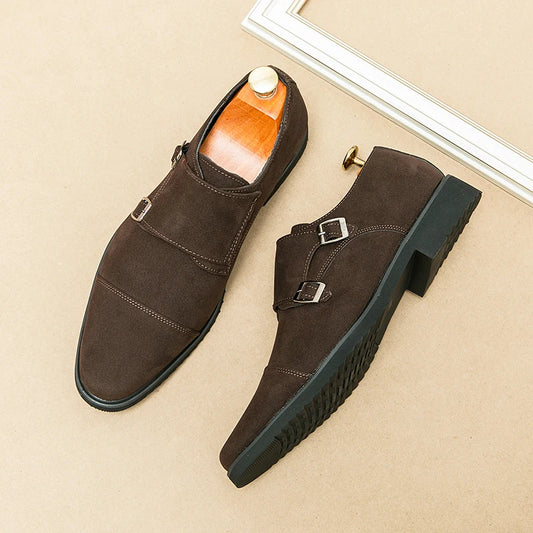 Brown suede shoes with buckles on a beige surface