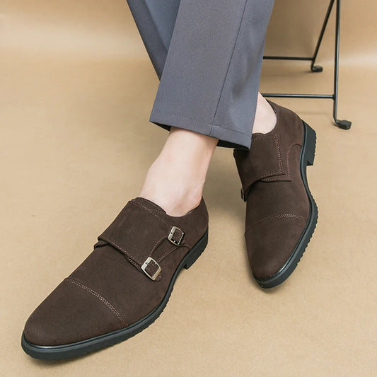 Brown suede shoes with buckles worn by a person on a beige floor.