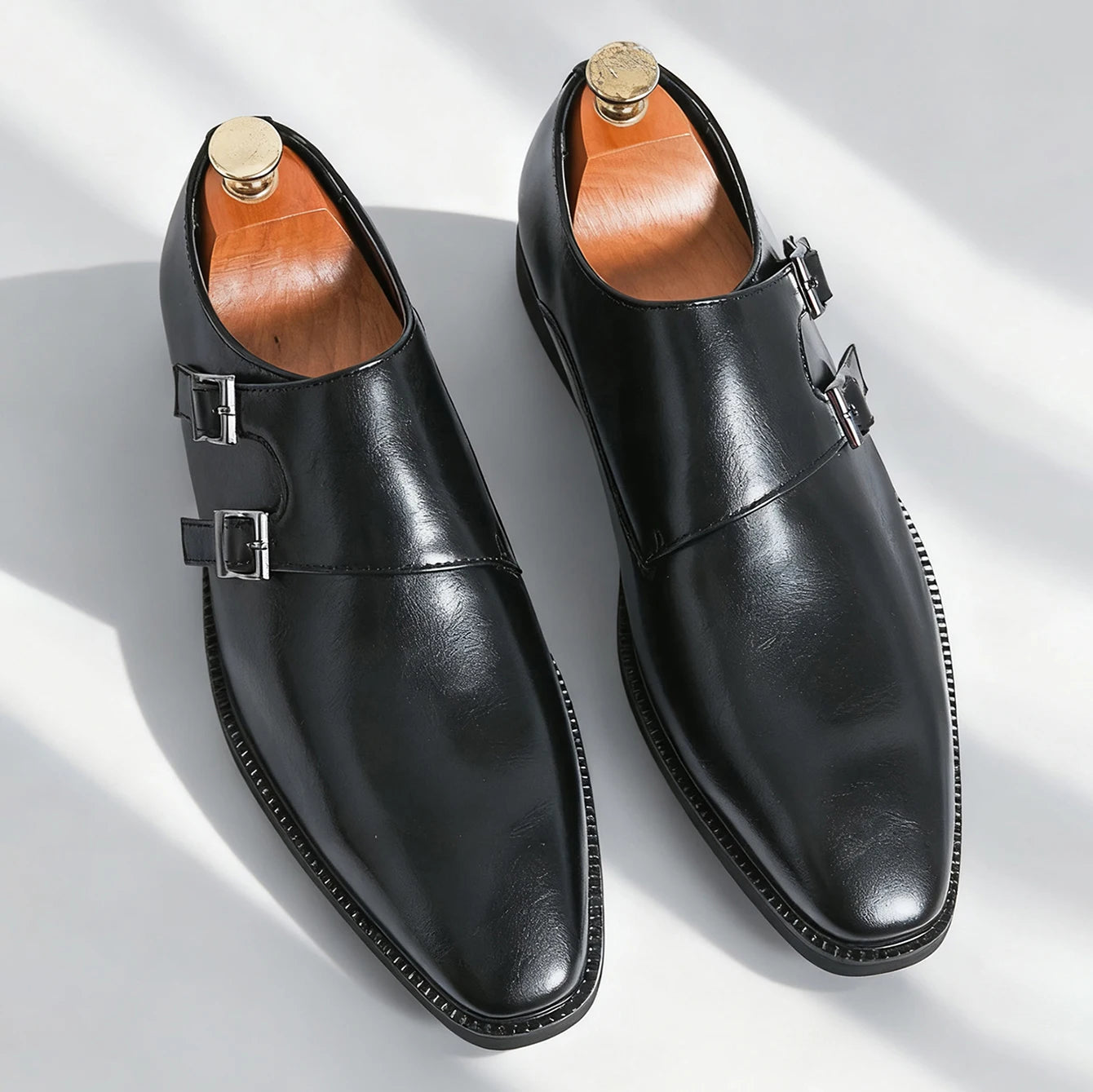 Pair of black leather shoes with buckles on a white background