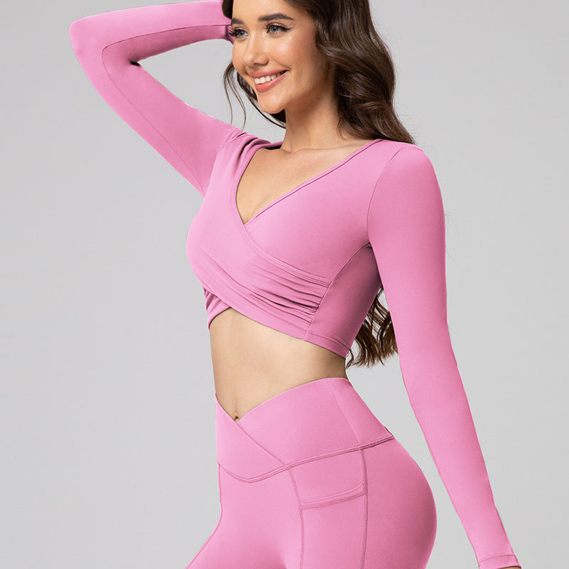 Woman wearing a pink long-sleeve athletic top and leggings on a gray background
