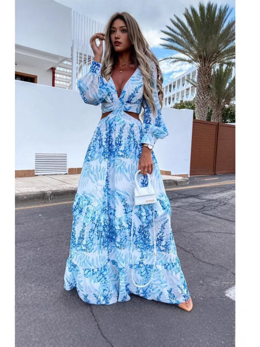 Woman in a blue floral dress standing on a street with palm trees in the background
