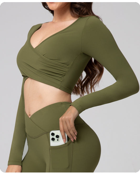 Green athletic outfit with long sleeves and a high waist on a gray background