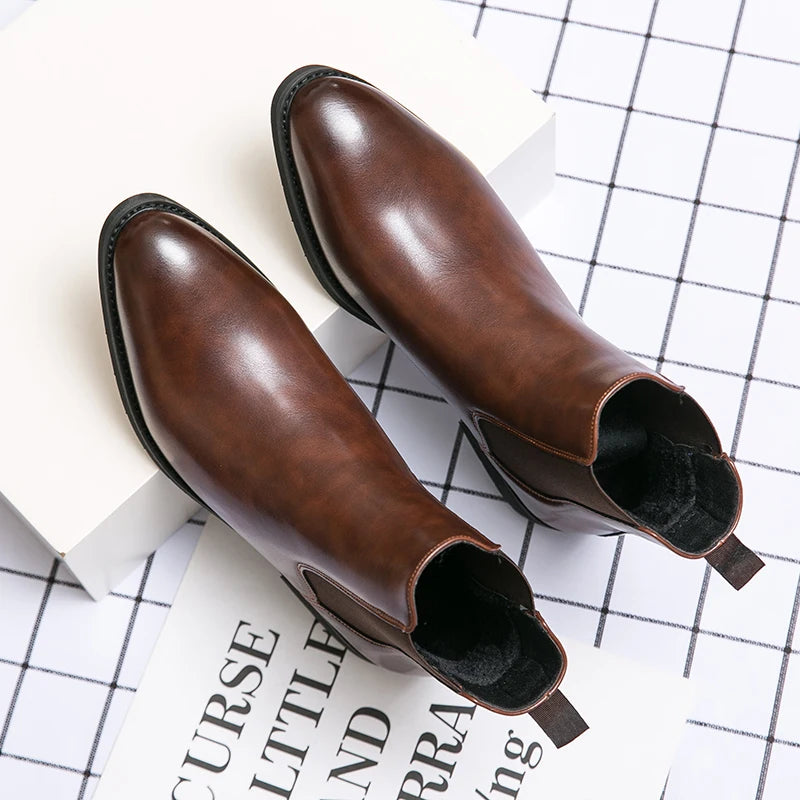 Pair of brown leather ankle boots on a white surface with a grid pattern