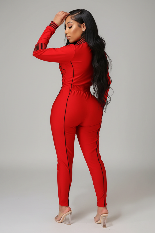 Person wearing a red jumpsuit standing in a room with a mirror and shelf.