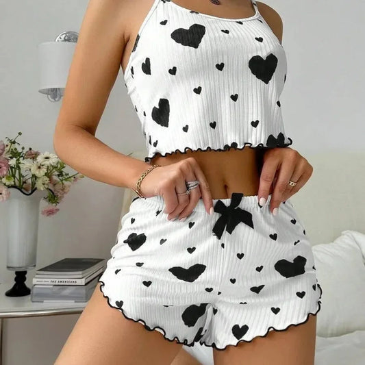 Person wearing a white top and shorts with black heart patterns in a casual setting.