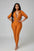 Person wearing an orange jumpsuit standing on a staircase.