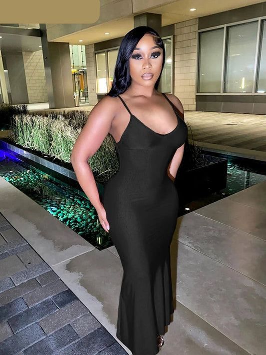 Woman in a black dress standing by a water