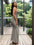 Woman in a gray dress standing on a wooden deck with greenery in the background