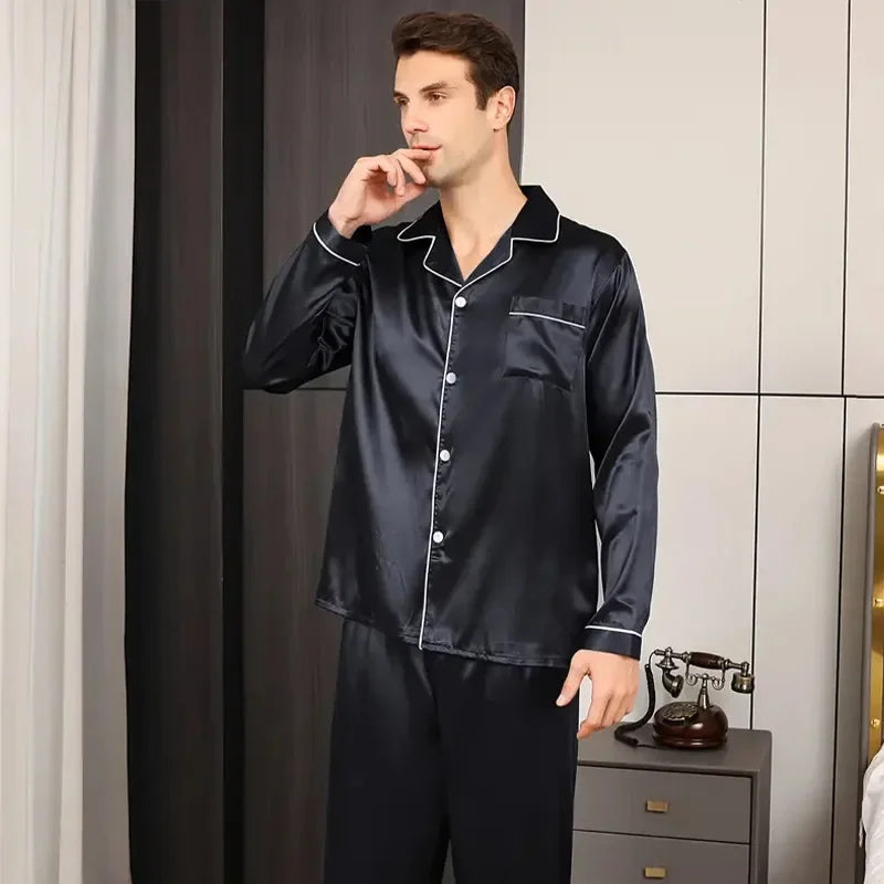Man wearing black satin pajamas in a bedroom setting.