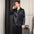 Man wearing black satin pajamas in a bedroom setting.