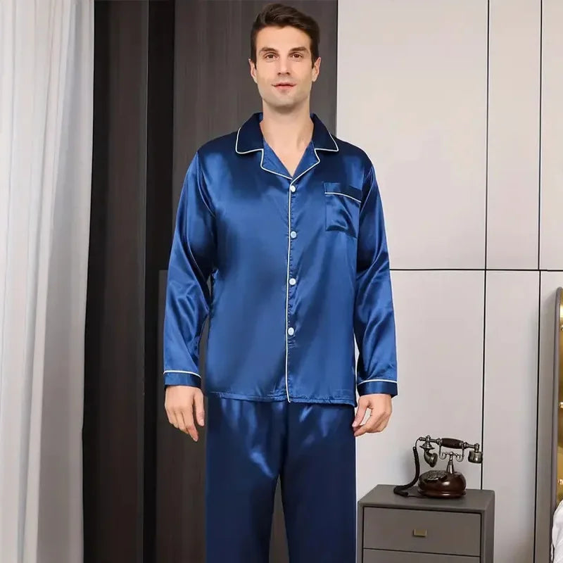Man wearing a blue satin pajama set in a room with a phone on a table.