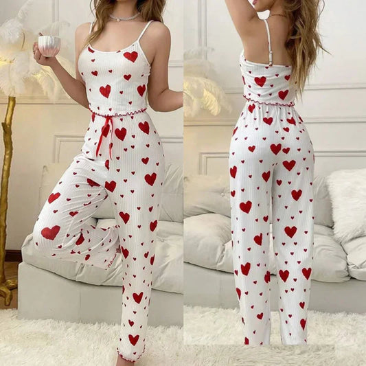 White jumpsuit with red heart patterns worn by a model in a living room setting.