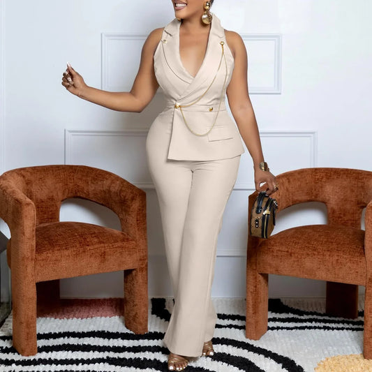 Woman in a beige outfit standing between two brown chairs on a black and white striped rug.