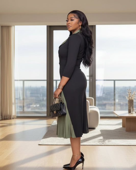 A woman in a black and green dress is holding a purse