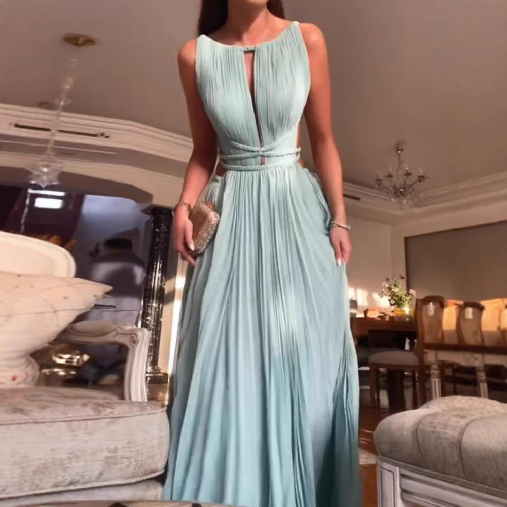 A woman in a light blue evening gown is standing in an elegant room with chandeliers.