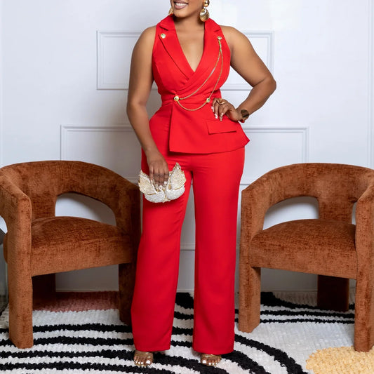 Woman in a red outfit standing in a room with two brown chairs and a black and white striped rug.