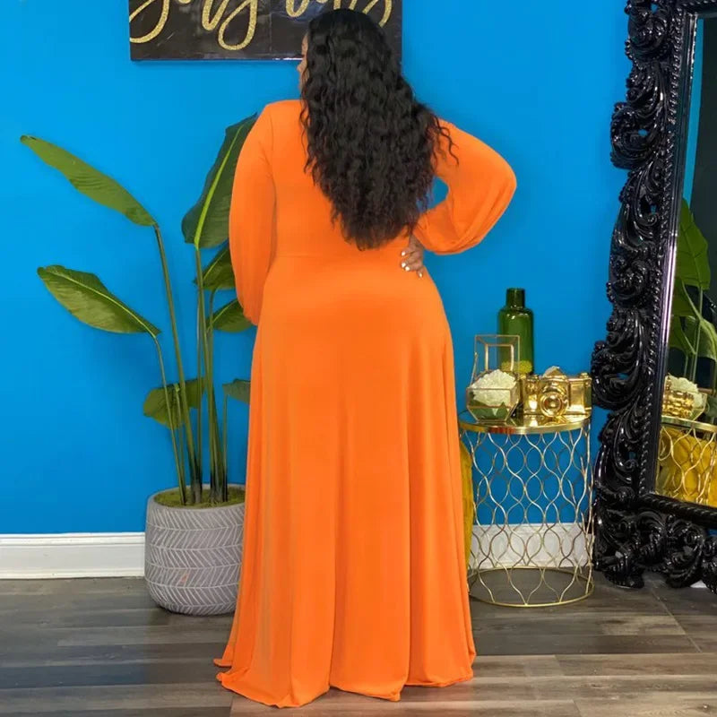 Woman in an orange dress standing in a room with a blue wall, decorative mirror, and plants.