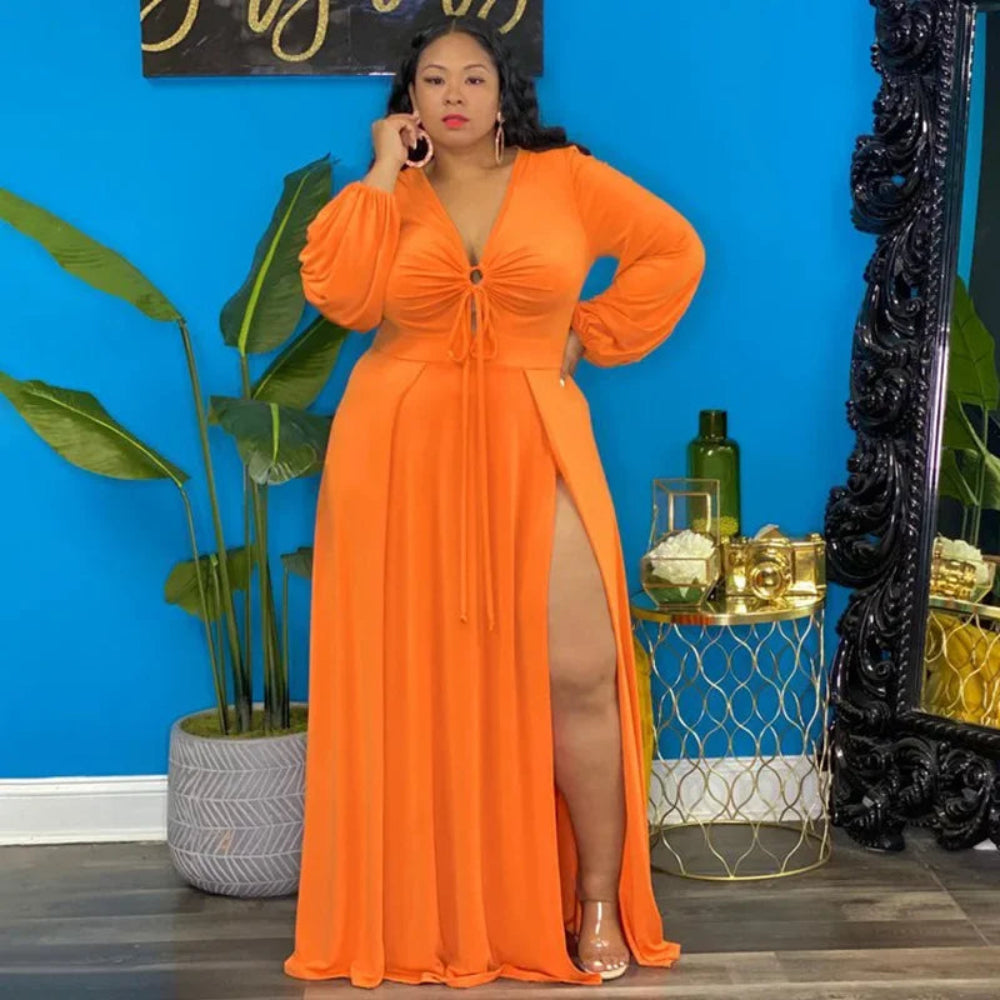 Woman in orange dress in room with blue wall, plants and decorative objects.