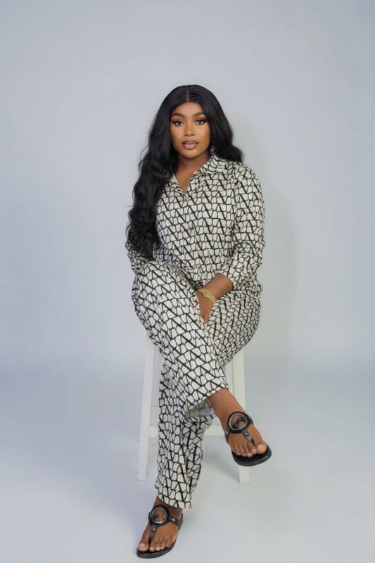 A woman in a patterned outfit is sitting on a brown leather couch with 'Joskaa' branding.