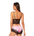 Woman wearing a black lace bra and pink satin shorts on a white background