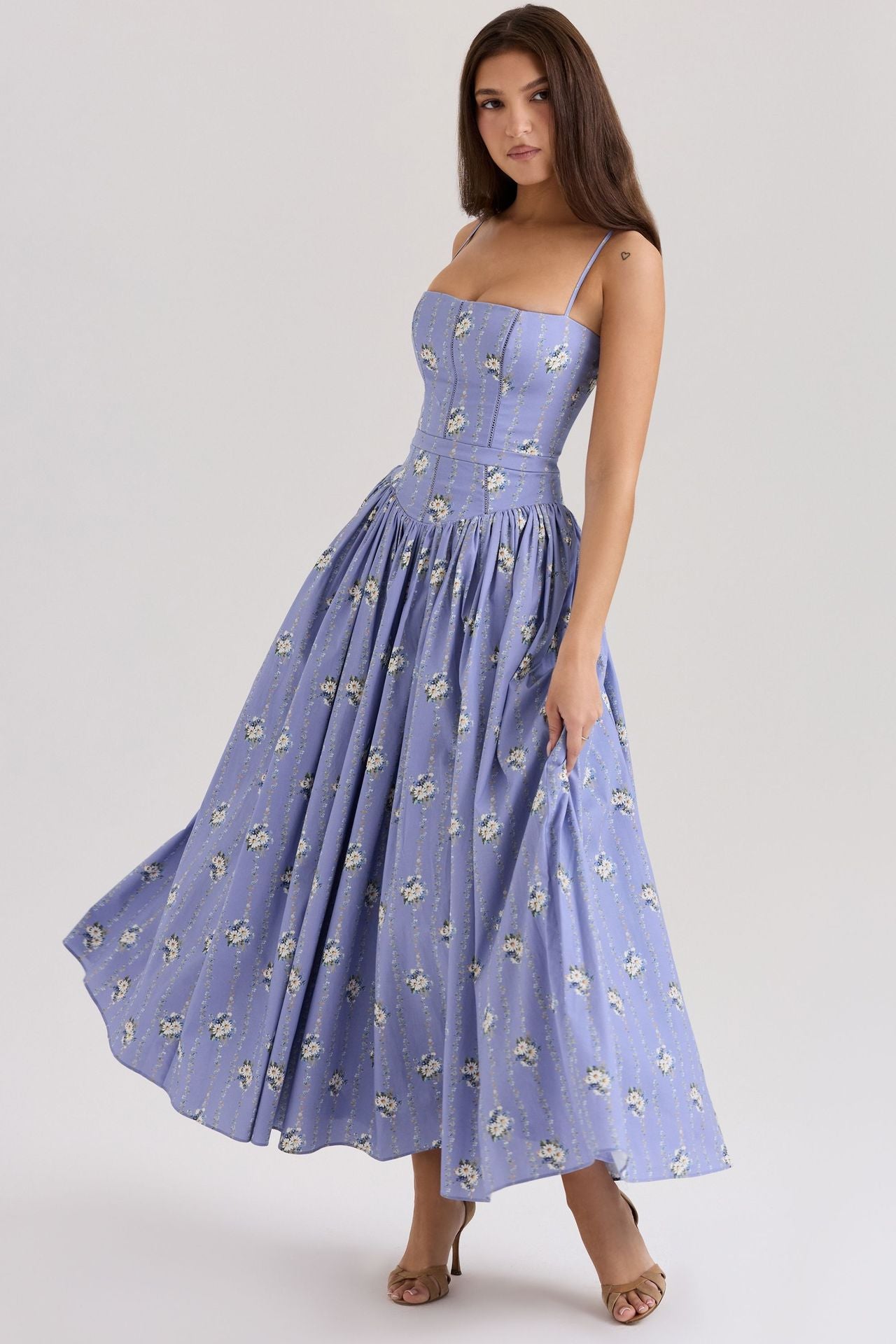 Woman wearing a blue floral dress on a white background