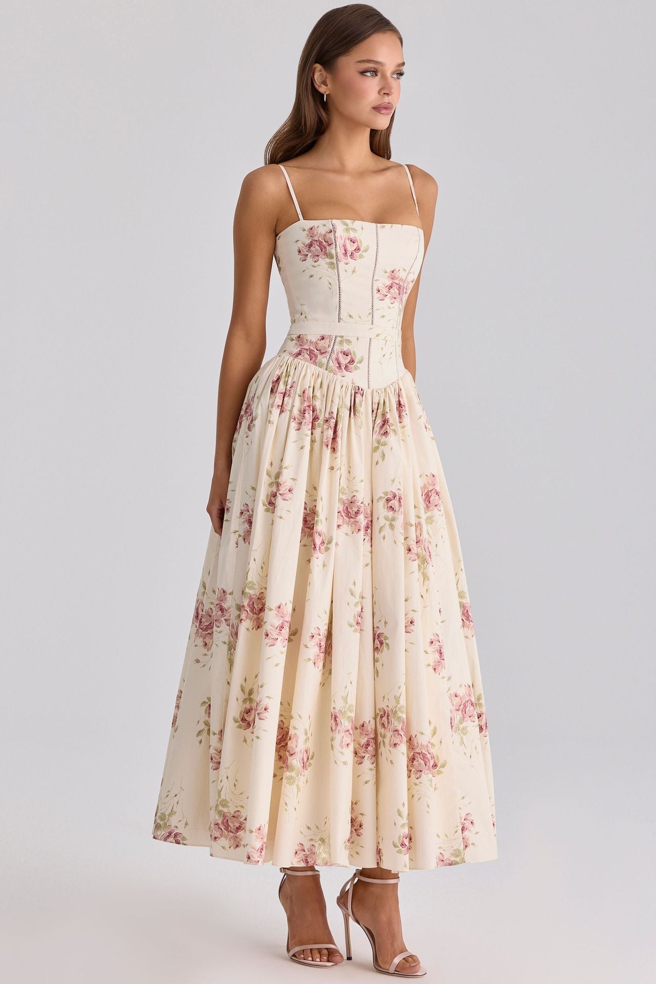 Woman wearing a floral dress on a plain background