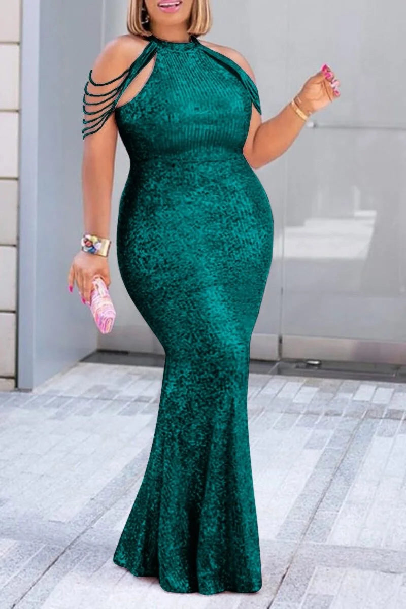 Woman wearing a green lace dress with cut-out shoulders in an urban setting.