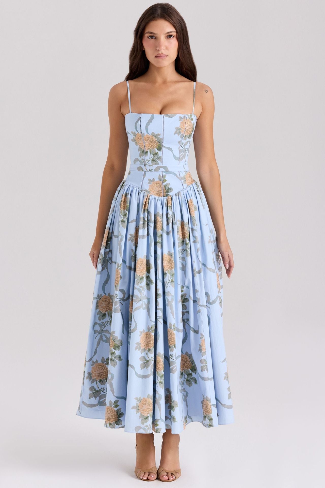 Woman wearing a light blue floral dress on a white background