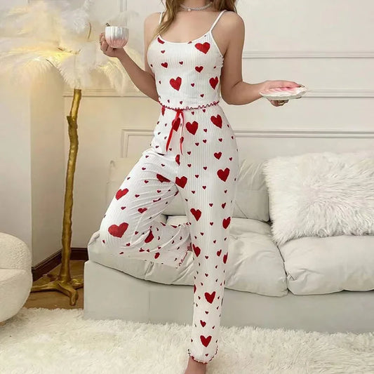 Woman wearing a white romper with red heart patterns in a living room.