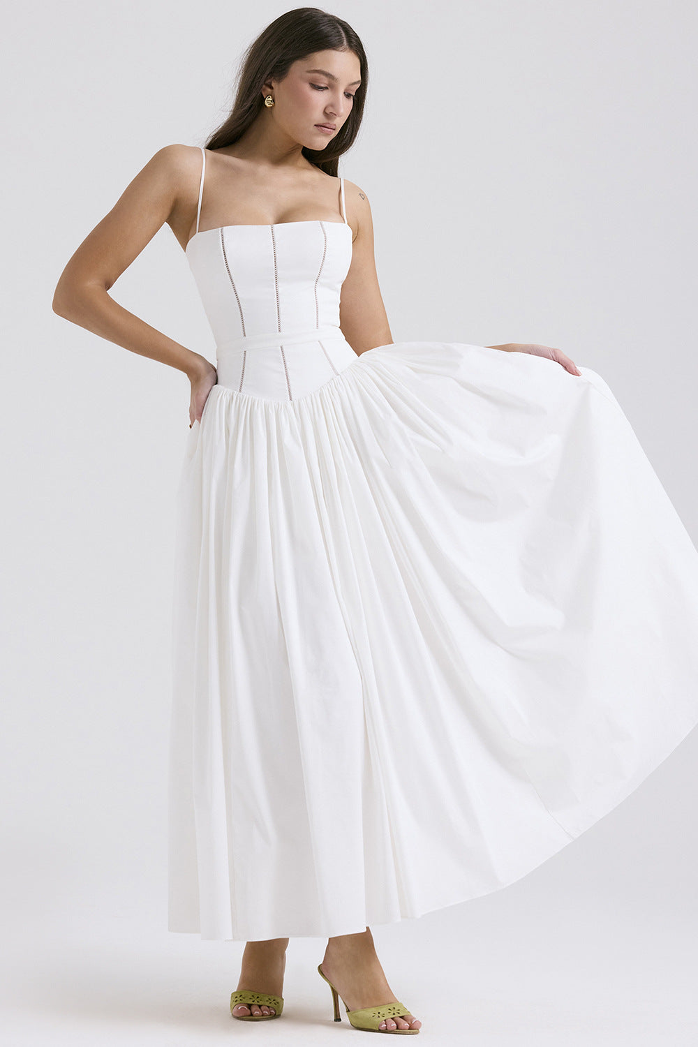 Woman wearing a white strapless gown on a plain background