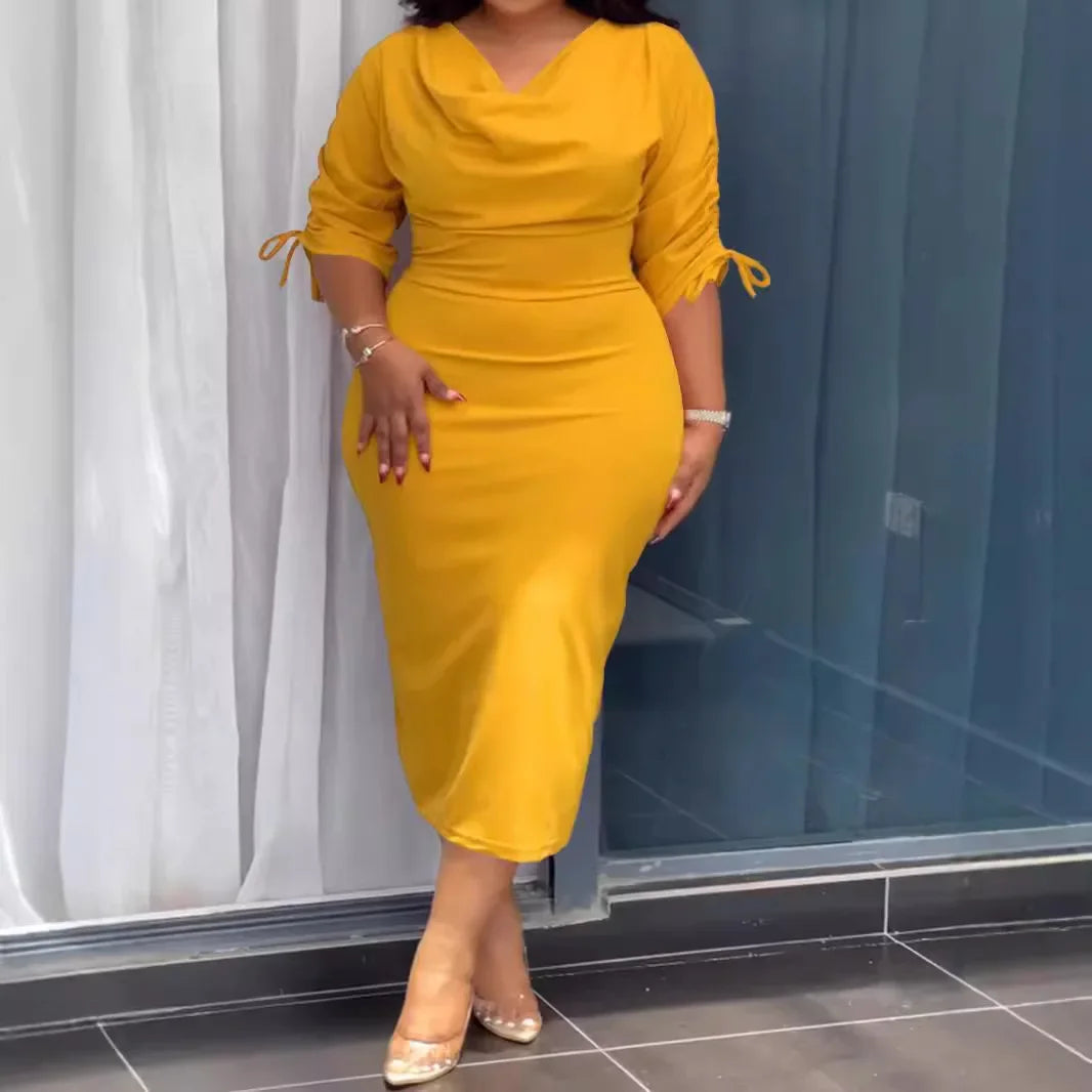 Woman wearing a yellow dress standing in front of a glass door.