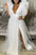 Woman wearing a white dress with ruffled sleeves in a living room setting.