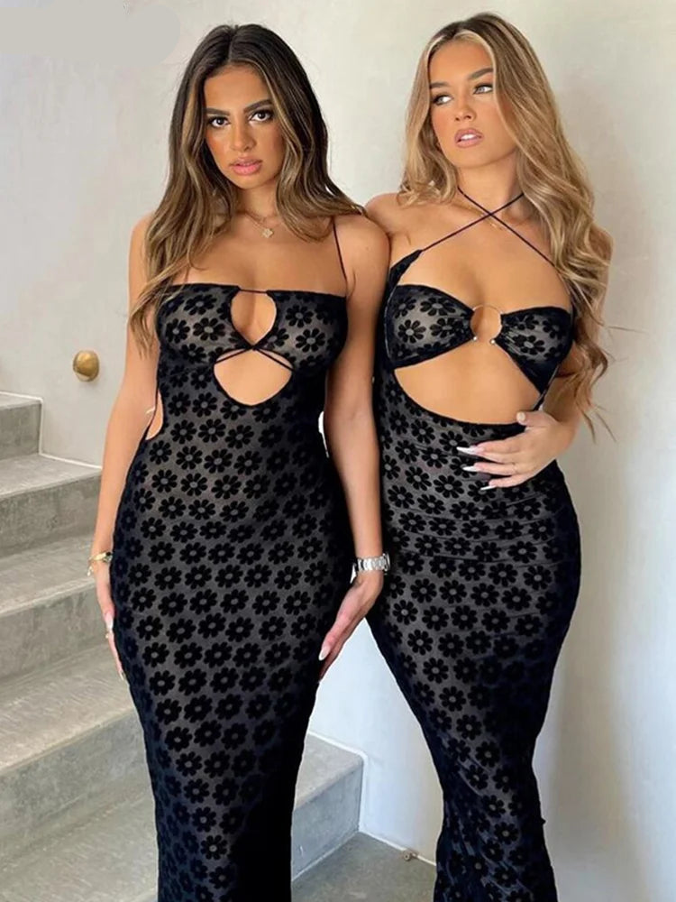 Two women wearing black lace dresses standing indoors.