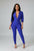 Person wearing a blue jumpsuit standing on a staircase.