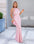 A woman in a pink evening gown stands outside on a tiled floor.